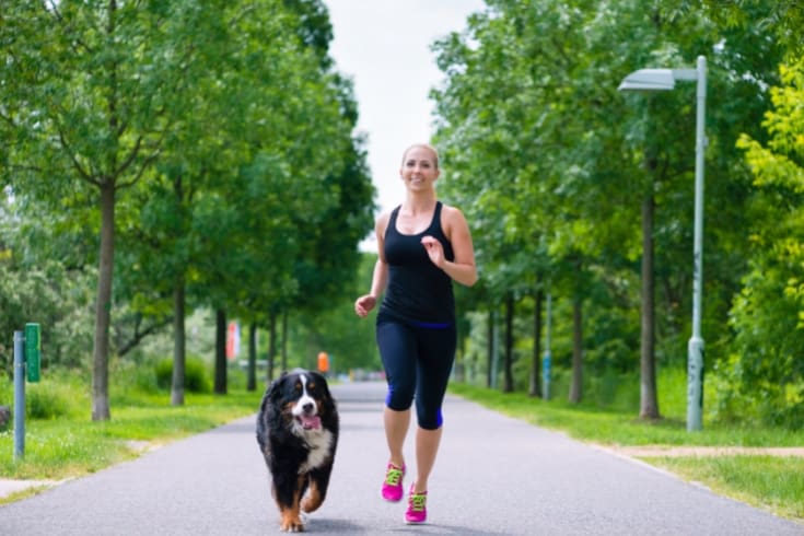Young Woman Running with Dog